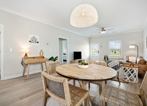 a living room and dining room with a table and chairs at The Cottages at Foley Farms apartments in Foley, AL
