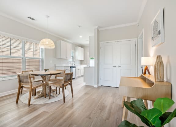 a dining room and kitchen with a table and chairs at The Cottages at Foley Farms apartments in Foley, AL