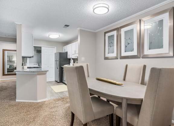 Carpeted dining room with overhead lighting adjacent to kitchen at Summerchase at Riverchase in Hoover, Alabama