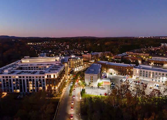 A cityscape at dusk with buildings and cars.