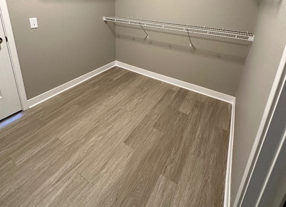 Empty walk-in closet with shelves and wood flooring at The Fitzroy Apartments in Birmingham, AL