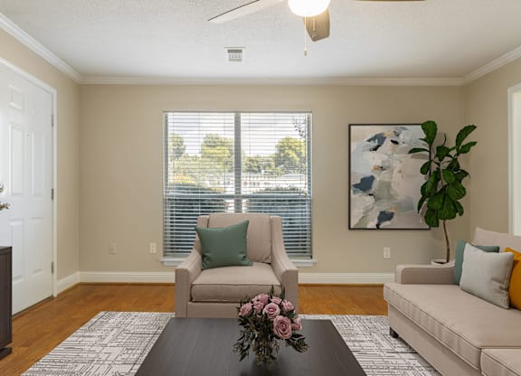 A living room with a brown couch, a chair, and a coffee table.