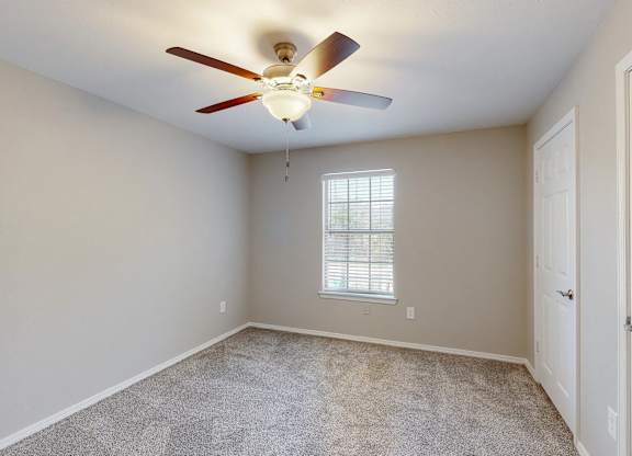 bedroom with plush carpet and ceiling fan at Grande View Apartments in Biloxi, MS