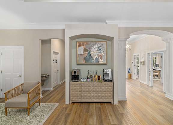 A living room with a wooden floor and a large painting on the wall.