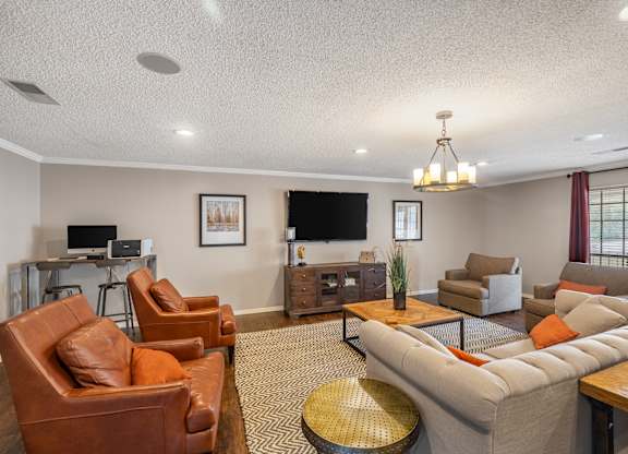 A living room with a brown leather chair and a grey sofa.