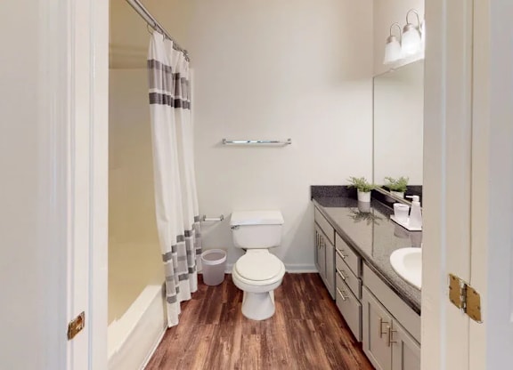 A white toilet with a white sink and a white cabinet.