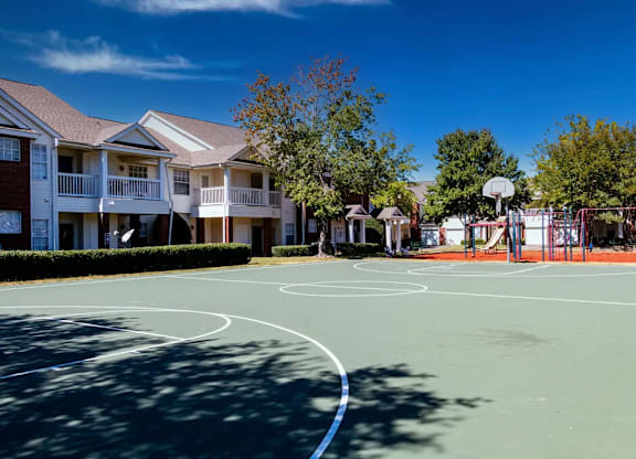 A basketball court is surrounded by apartment buildings.