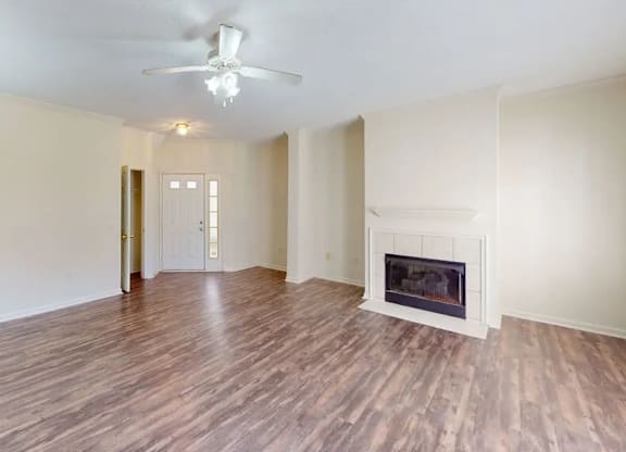 A room with a fireplace and wood flooring.