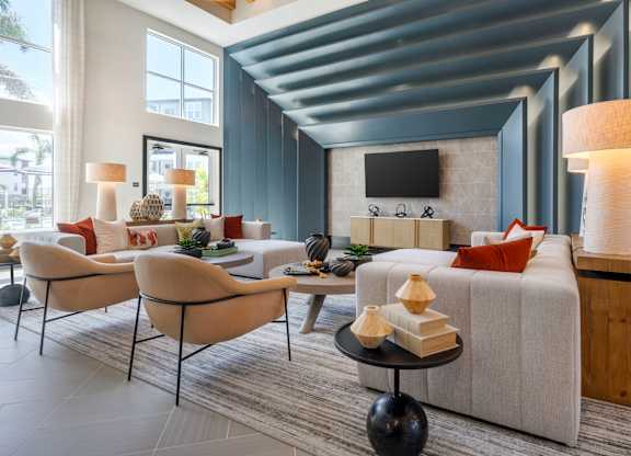 A modern living room with a grey sofa, a wooden coffee table, and a TV mounted on the wall.