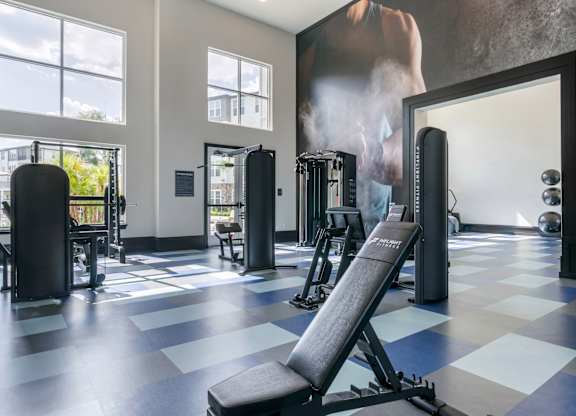 A gym with a variety of equipment including a bench press.