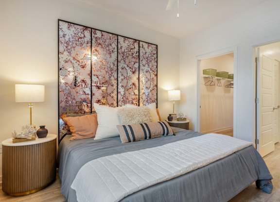 A bedroom with a large bed and a floral wallpaper.