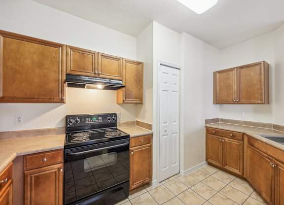 a kitchen with wooden cabinets and a stove and a sink