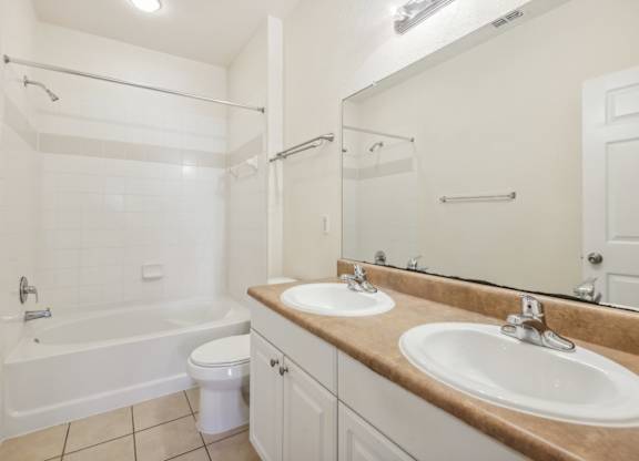 a bathroom with two sinks and a tub and a toilet