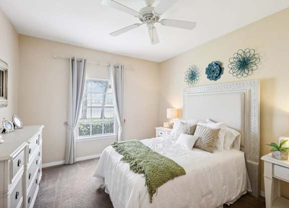 a bedroom with a bed and a ceiling fan