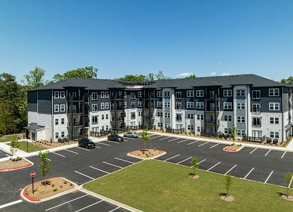 A large, modern building with a parking lot in front.