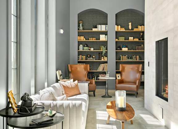 A modern living room with a white sofa, a wooden coffee table, and a fireplace.