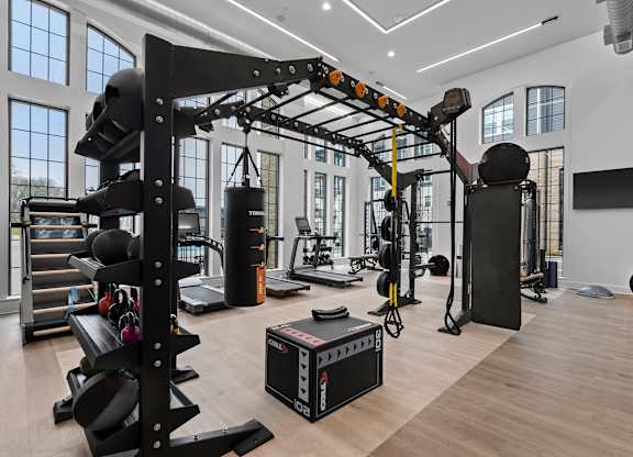 A gym with a variety of equipment including a squat rack, bench, and weights.