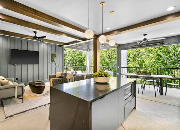 A modern kitchen with a large island and a television mounted on the wall.