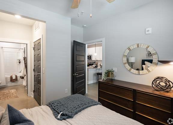 A bedroom with a bed, dresser, and mirror.