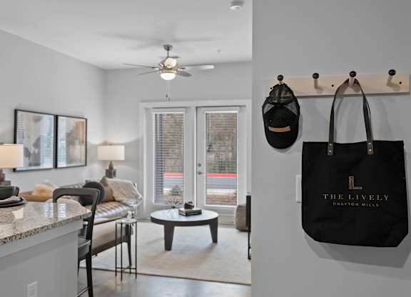 A black bag hangs on a hook in a room with a ceiling fan.