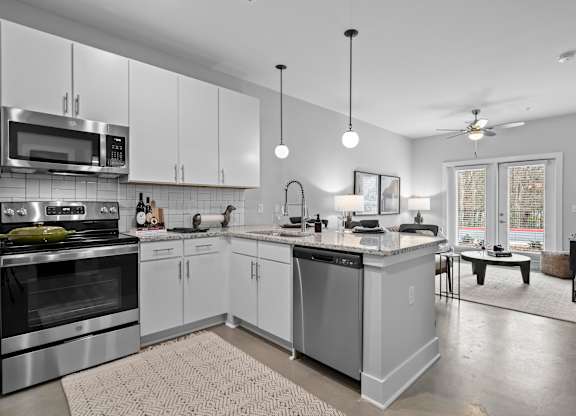 A modern kitchen with stainless steel appliances and white cabinets.