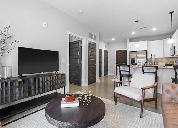 A modern living room with a black entertainment center and a brown leather couch.