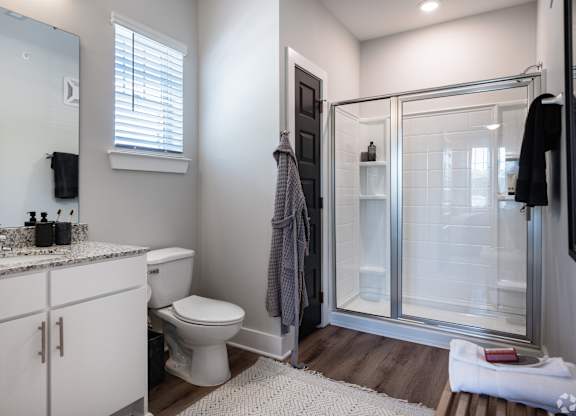 A bathroom with a toilet, sink, and shower.