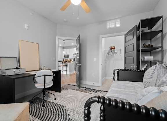 A bedroom with a bed, desk, and chair.