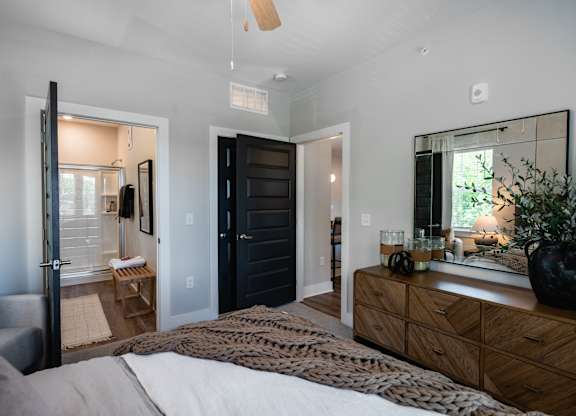 A bedroom with a bed, dresser, and mirror.