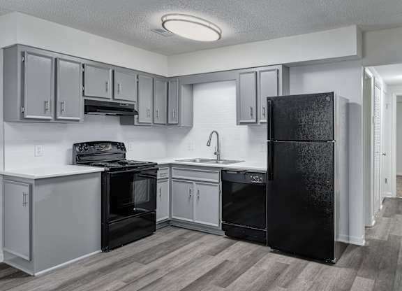A kitchen with black appliances and white cabinets.