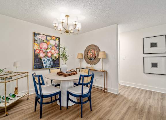 A dining room with a white table and blue chairs.