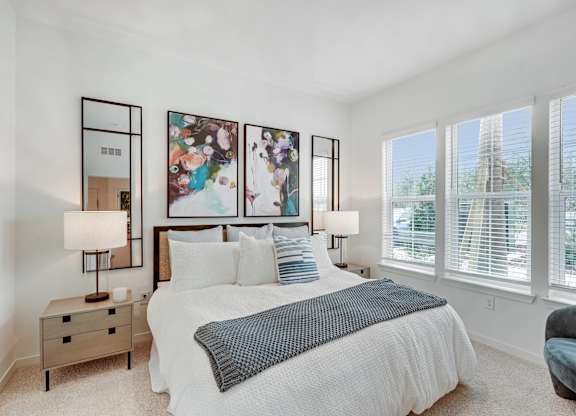A bedroom with large windows at Tapestry University Park apartments in Sarasota, FL