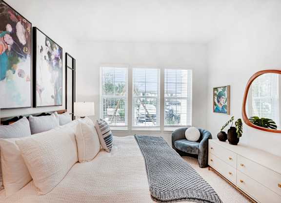 Primary bedroom with large windows at Tapestry University Park Apartments in Sarasota, FL