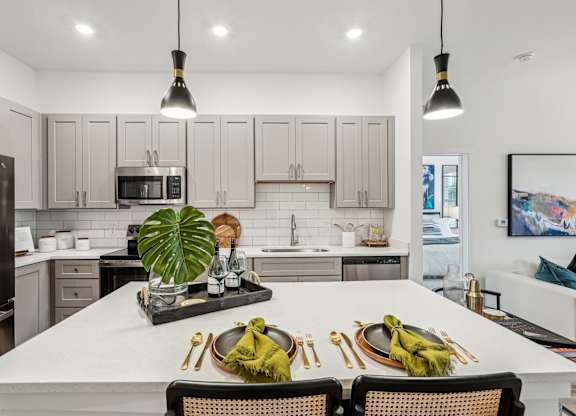 A modern kitchen with island and stainless steel appliances at Tapestry University Park apartments in Sarasota, FL