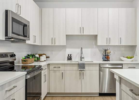 A kitchen with white cabinets and stainless steel appliances.