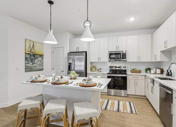 A modern kitchen with a dining table set for four.