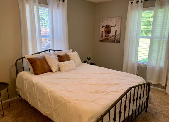 bedroom with two windows and plush carpet at The Avery at Auburn Apartments in Auburn, AL