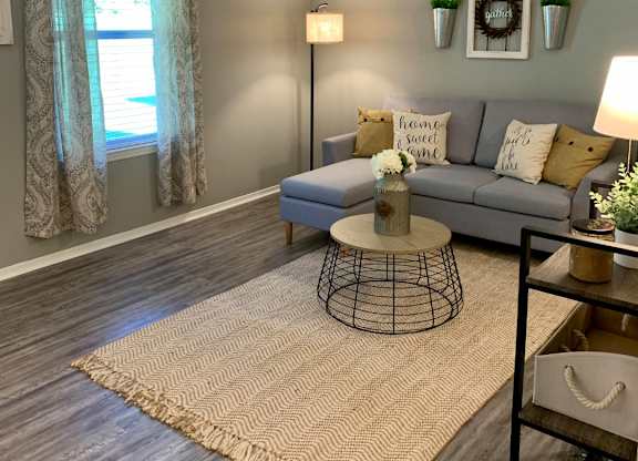 Living room with window and plank flooring at The Avery at Auburn Apartments in Auburn, AL