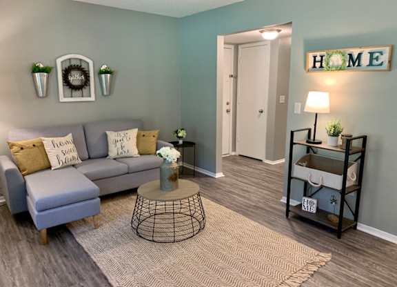 A living room with wood-desgined flooring and open floor plan at The Avery at Auburn Apartments in Auburn, AL