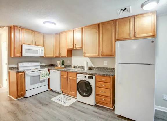 A kitchen with wooden cabinets and white appliances.