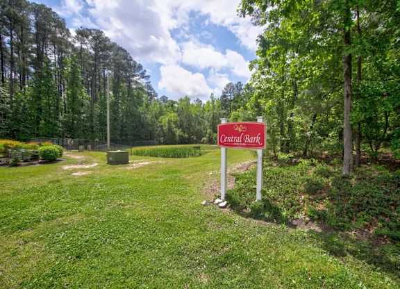 A sign that says Central Bark stands in a grassy area.
