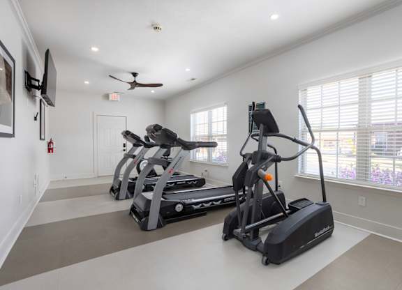 A spacious room with a treadmill and elliptical trainer.
