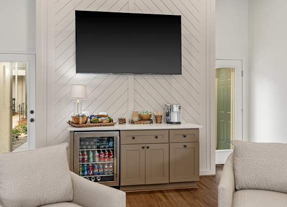Complimentary beverage area in the clubhouse at Oakley at Hillcrest with a large tv