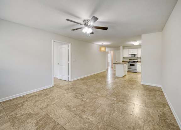 A room with a ceiling fan and tiled flooring.