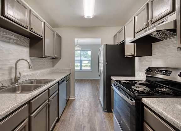 A kitchen with a black refrigerator and stove.