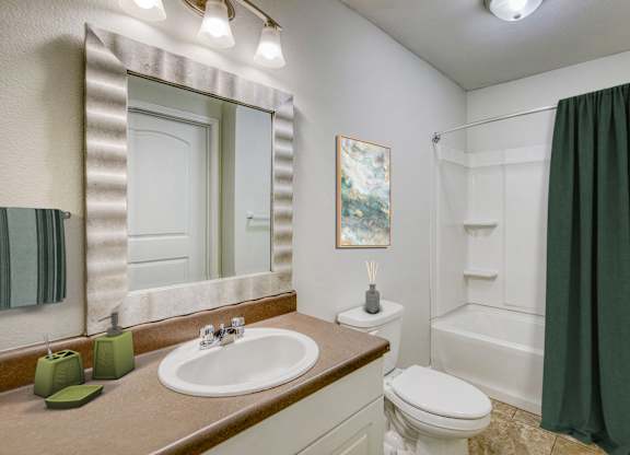 A bathroom with a sink, toilet, and shower.