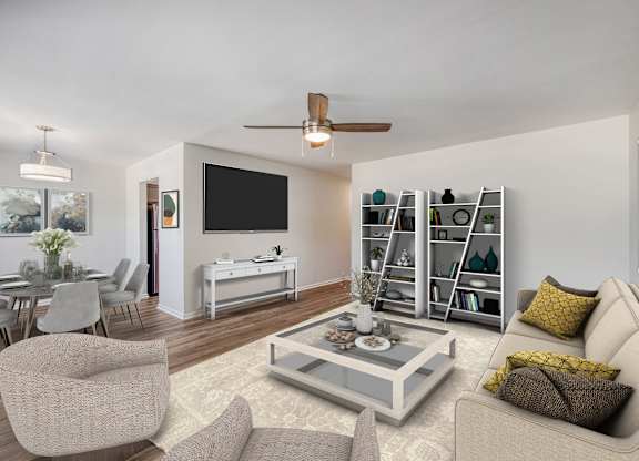 A modern living room with a grey sofa, a glass coffee table, and a television.