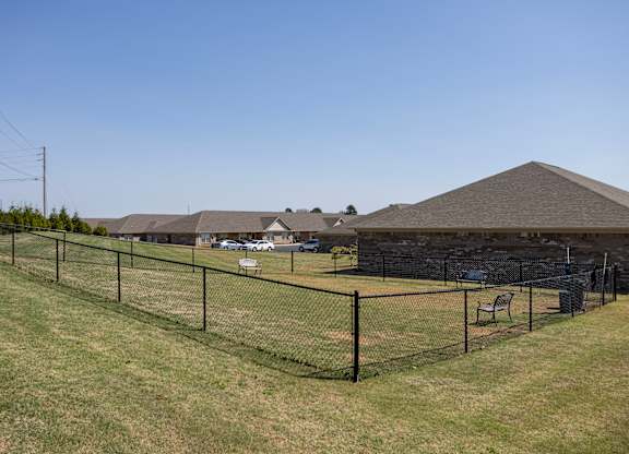 A black fence runs along a grassy field.