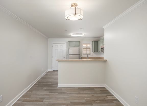 A room with a white door and a light brown floor.