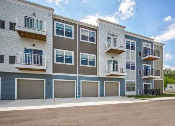 an apartment building with balconies and garages at The Promenade at Founders Square in Portage, IN